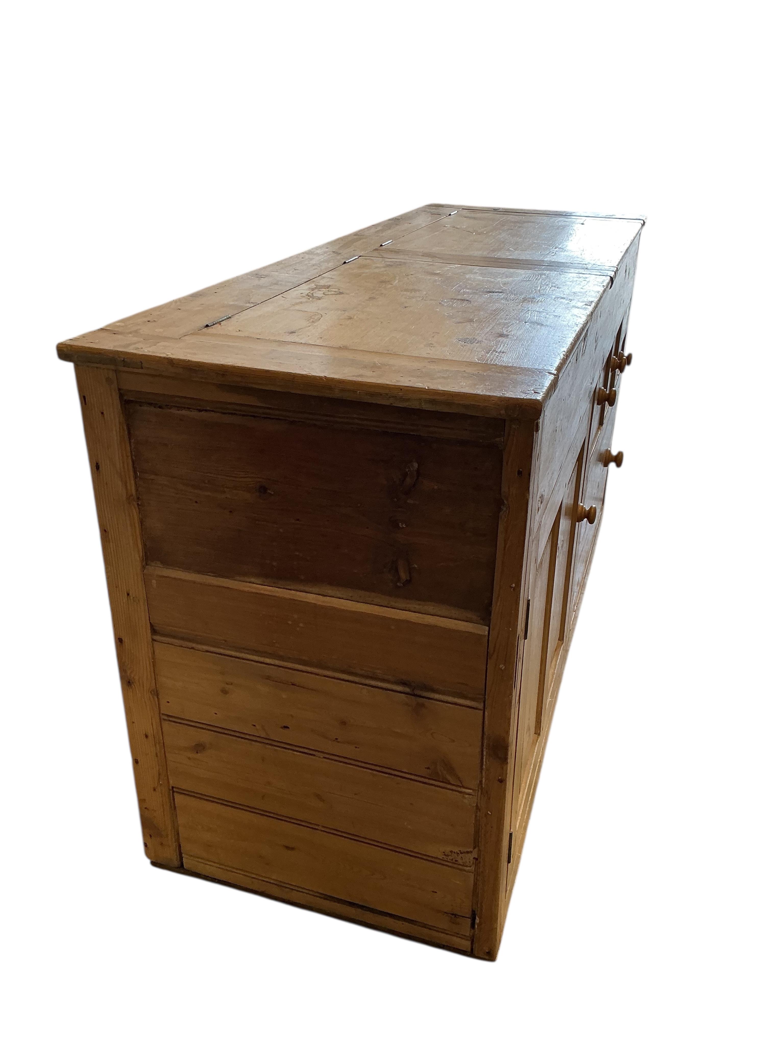 A Victorian pine low dresser with twin hinged compartment top, width 150cm, depth 53cm, height 80cm
